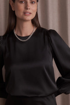 Woman wearing Original Story black puff sleeve blouse