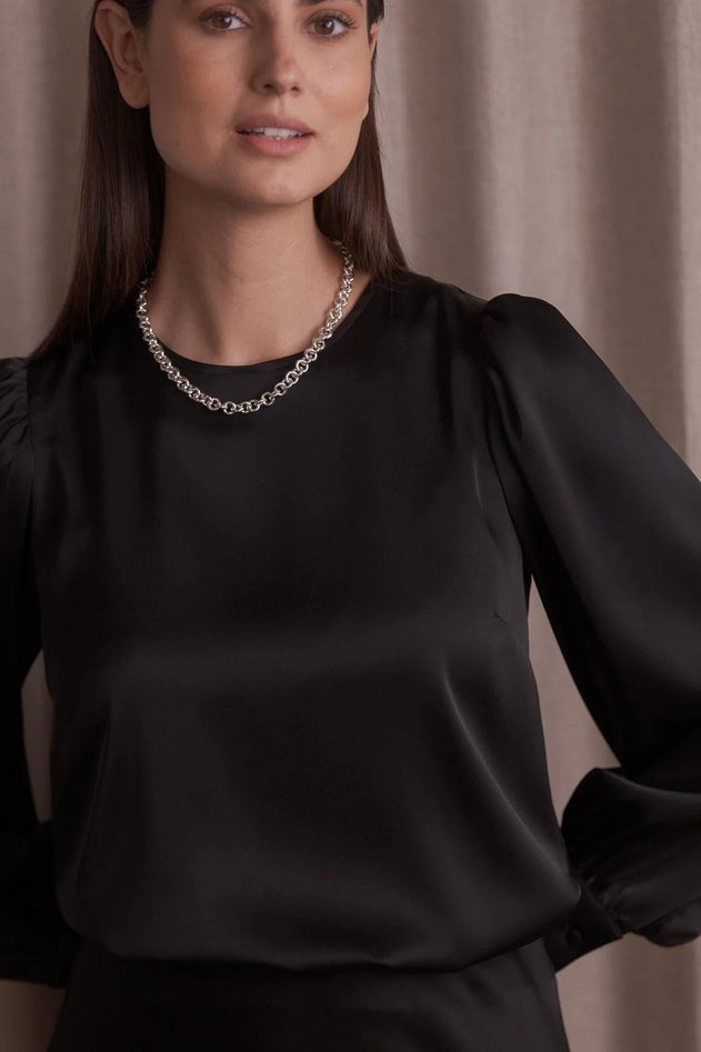 Woman wearing Original Story black puff sleeve blouse