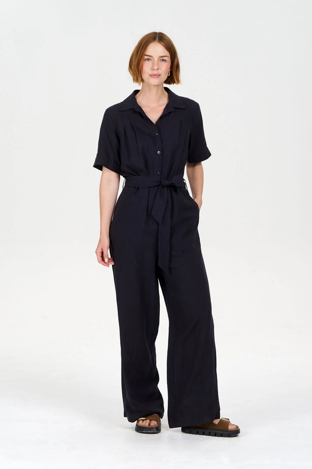 Woman wearing a black jumpsuit on a white background